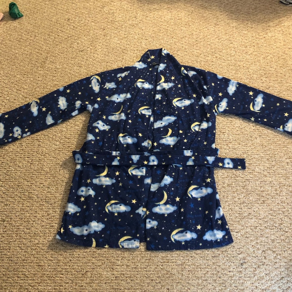 A cute soft robe with clouds, stars and moons. It says “I love sleep”.